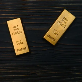 Stacks of gold bullion bars on a dark surface
