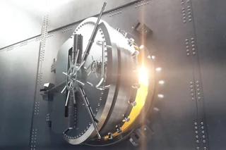 Open bank vault door with golden light from inside